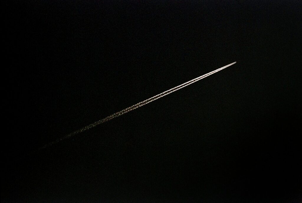 an airplane is flying through the dark sky