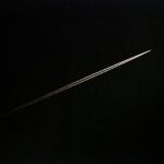 an airplane is flying through the dark sky